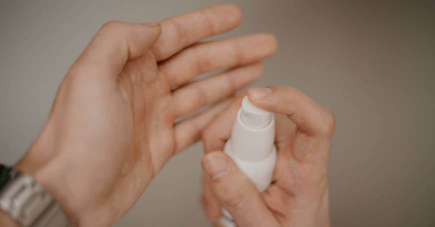 Prikaz ruku koje nanose kozmetički proizvod iz bočice