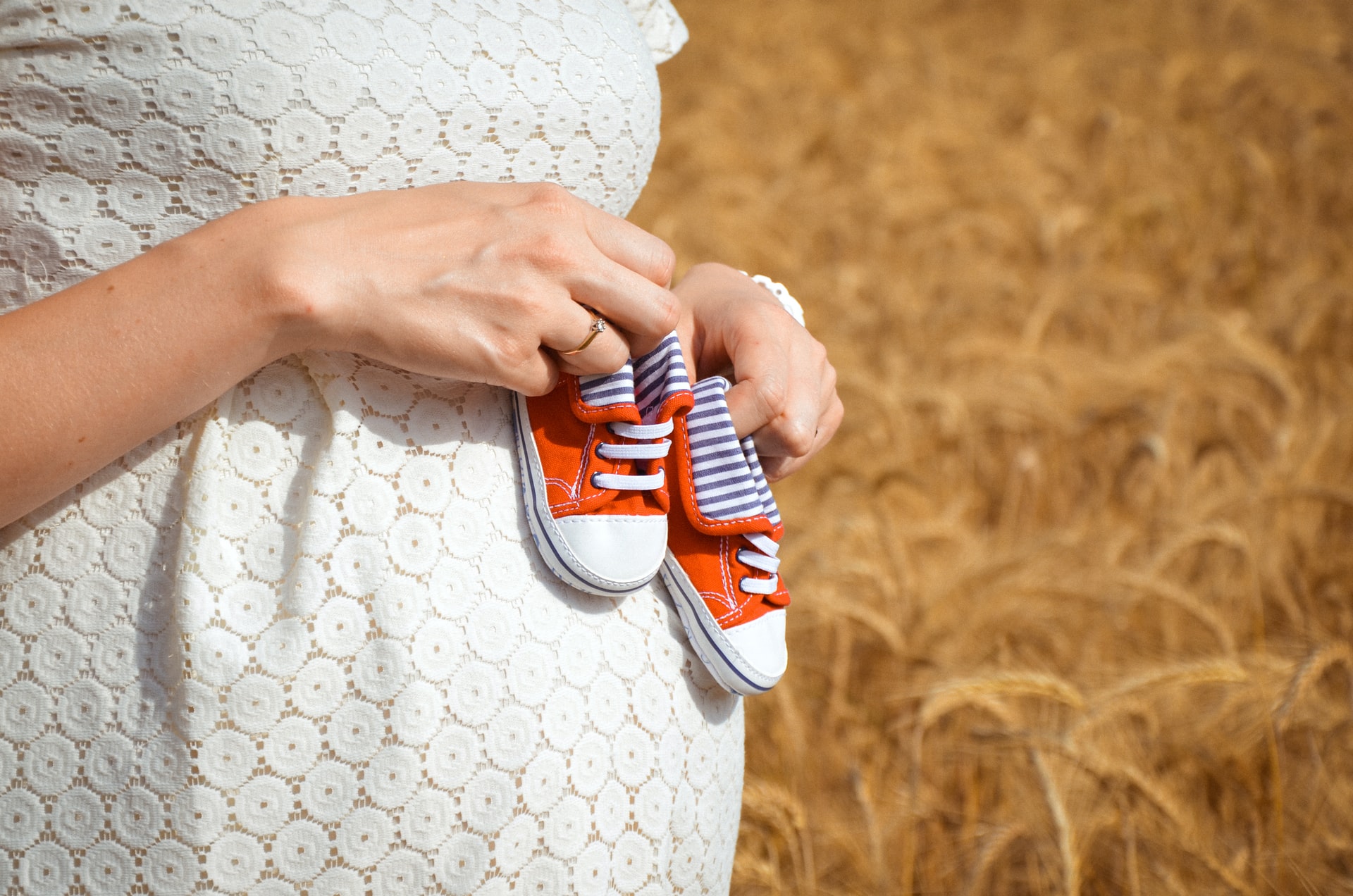 prikaz trudnice koja drži cipelice za bebu
