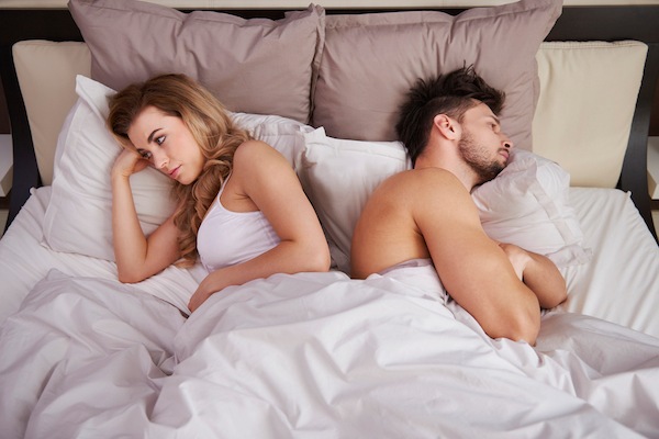 Erektilna disfunkcija - muškarac i žena okrenuti leđima leže u krevetu,