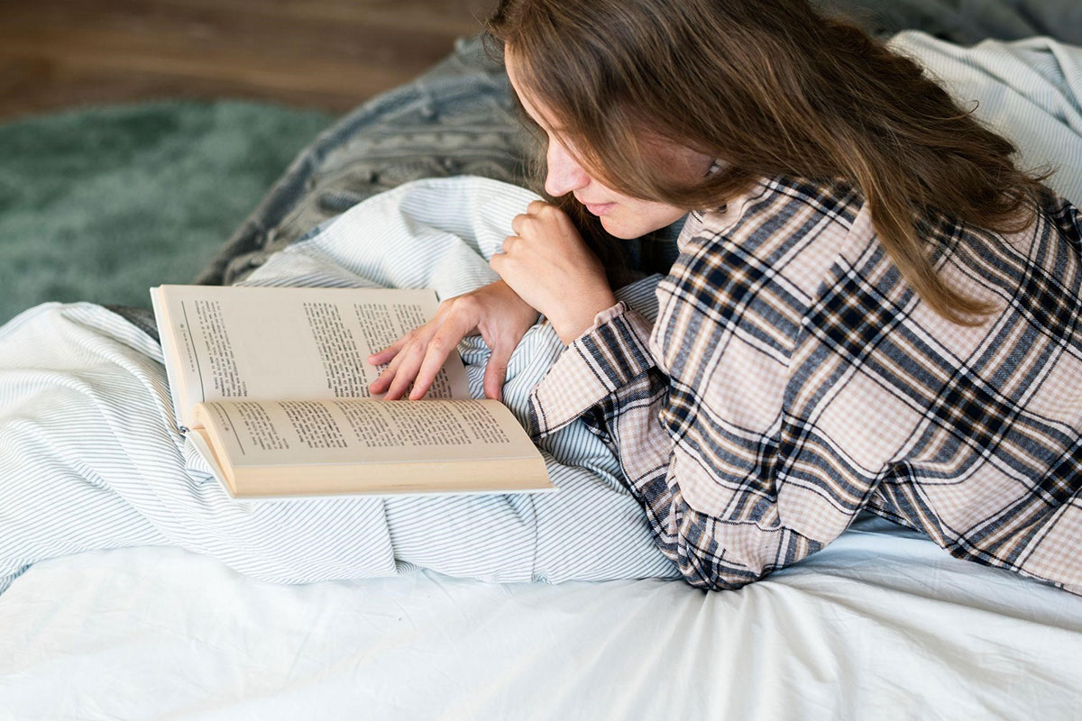 Devojka čita na krevetu