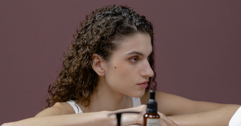 Žena sa kovrdžavom kosom, i kapi za kosu ispred nje.