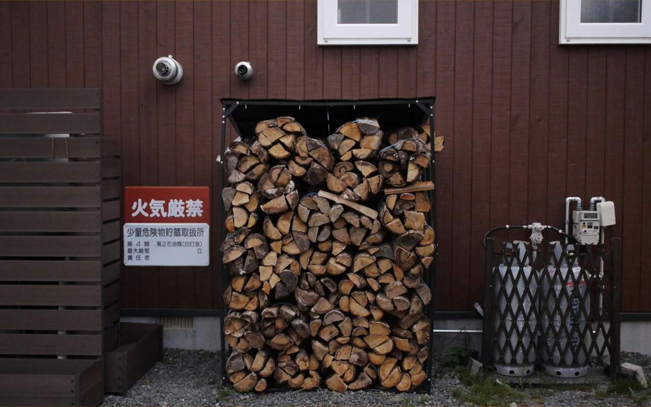 Drva za ogrev poređana su u skladišnom prostoru iza kuće.