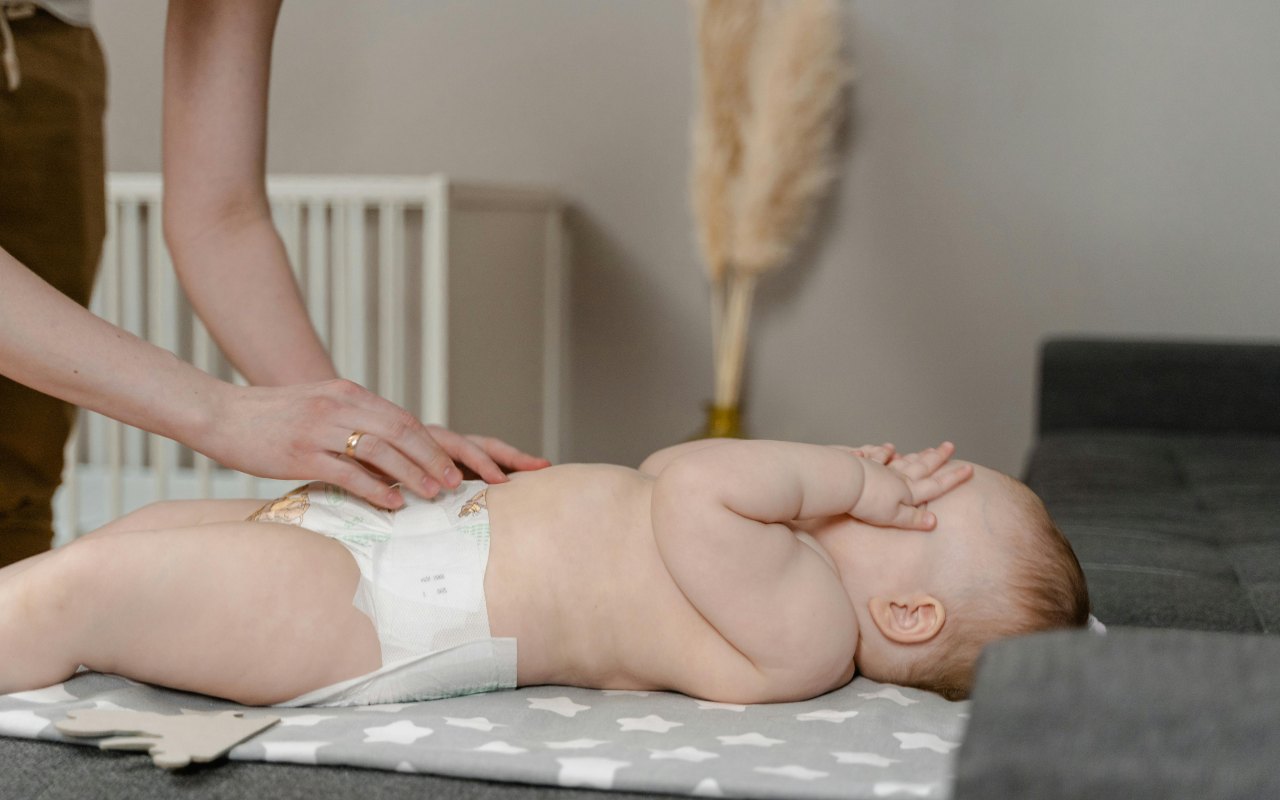 Žena presvlači bebu na kauču