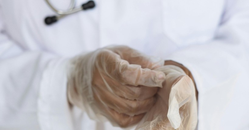 Doktor stavlja rukavice na ruke